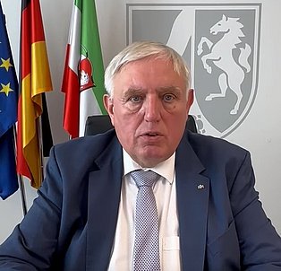 Mann mit grauen Haaren, dunkler Anzug
